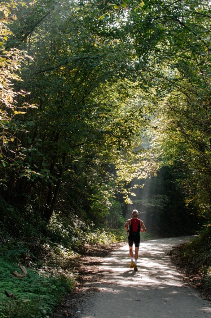 hombre corriendo por un sendero en el bosque con tenis para senderismo